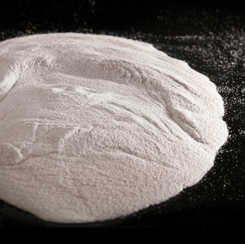 Small circular pile of white powder against a black surface.