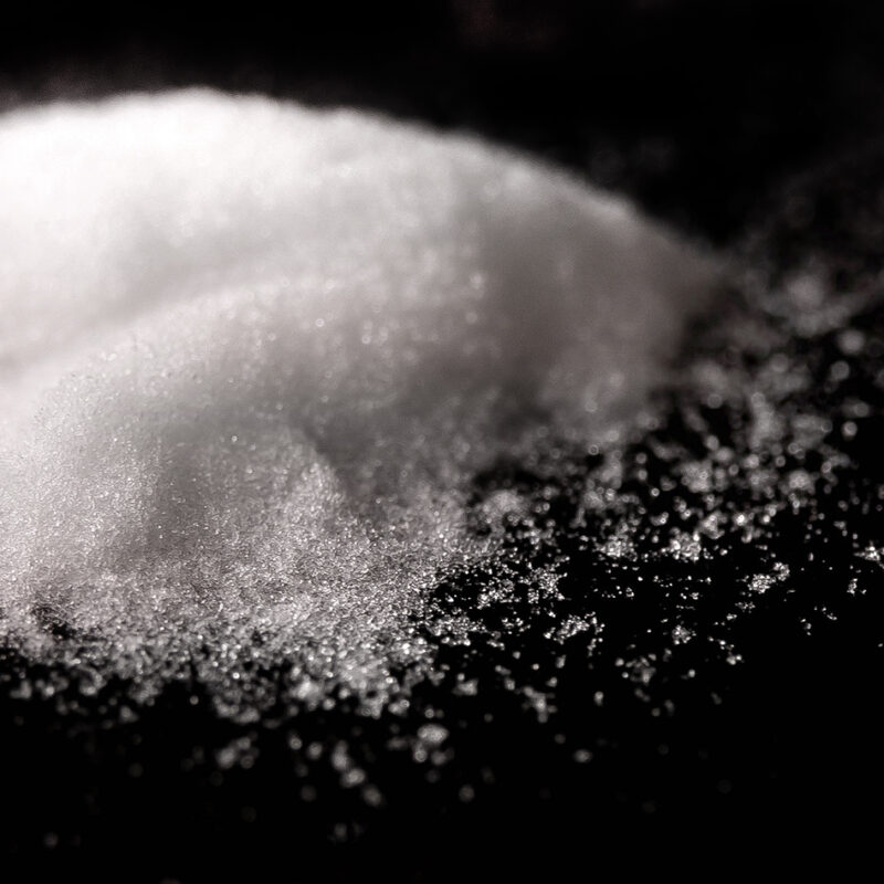 Close up shot of white powder in a mound on a black background.